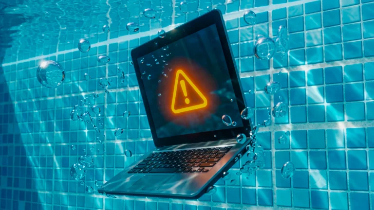 sinal de alerta em amarelo na tela de um notebook. O notebook está dentro da água de uma piscina. Todos os elementos simbolizam a queda de tráfego no GA4.