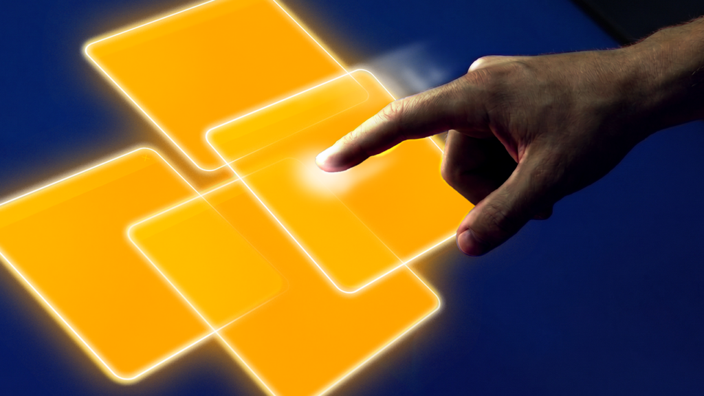 Mão tocando com o dedo indicador um painel digital luminoso e alaranjado que parece flutuar junto a outros semelhantes. A interação ocorre sobre um fundo azul escuro sólido.